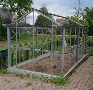 The framework of the greenhouse made from repurposed materials is done